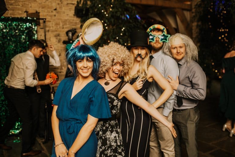 guests at wedding wearing props for mad hat photo booth promo video