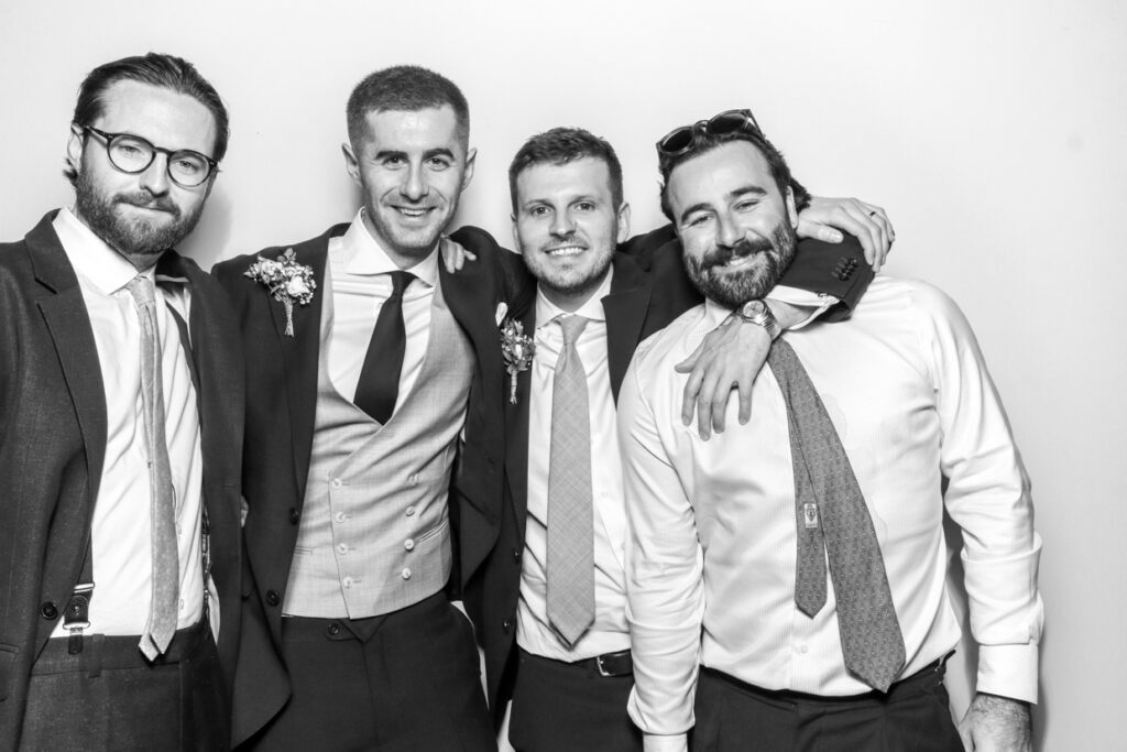 4 guests, including the groom posing during a wedding party entertainment  with a white backdrop for a Gloucester Photo Booth