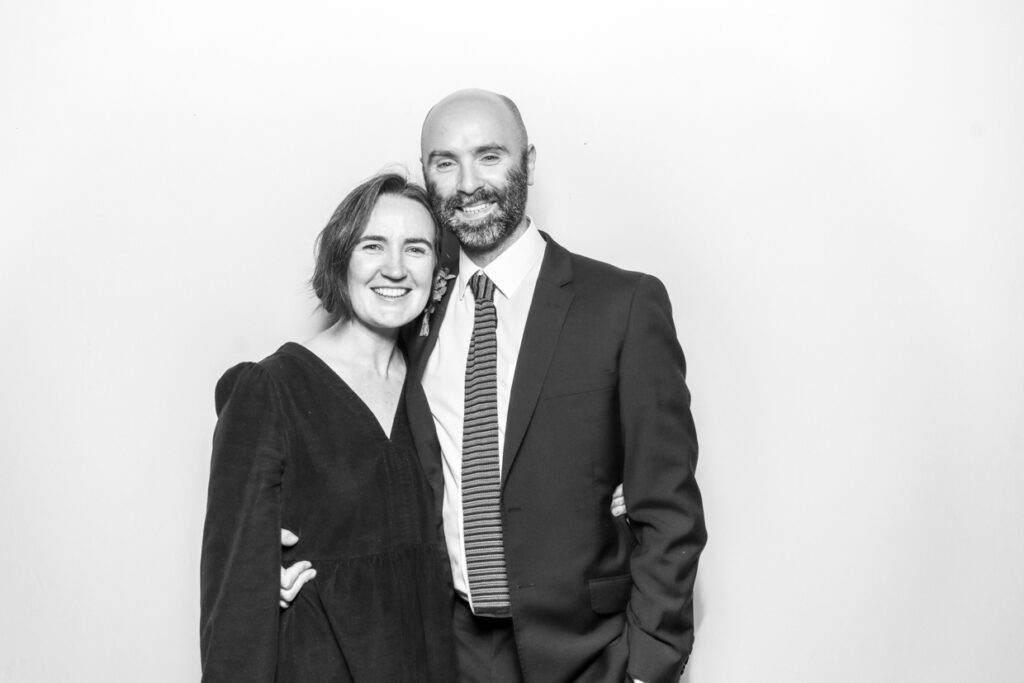 2 guests during a corporate event party entertainment in gloucester, posing against a white backdrop, for a black and white filter