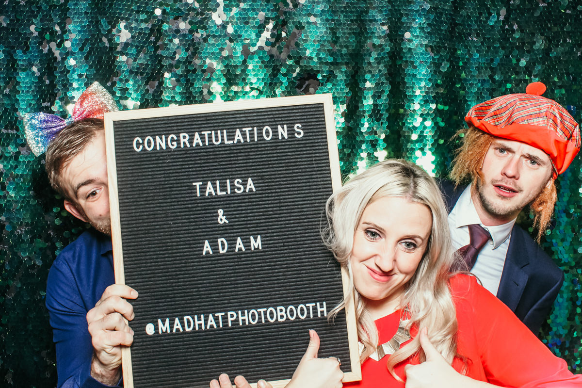 guests posing for a photo booth at elmore court, holding the letters board by mad hat photo booth cotswolds based