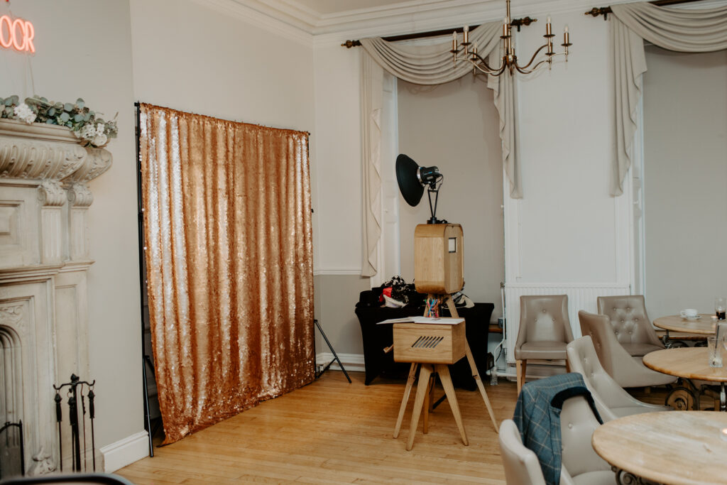 eastington park photo booth setup with blush sequins backdrop and wooden photo booth, by mad hat photo booth
