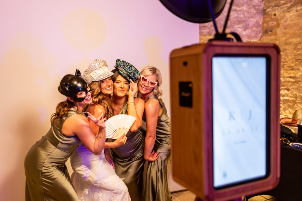 bride and bridesmaids posing for ivy lodge photo booth rental for their party entertainment hire in Cirencester
