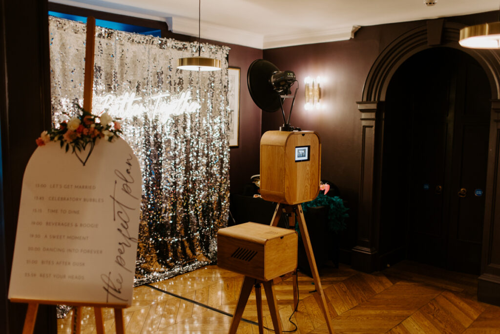 the slaughters manor house photo booth setup with retro wooden booth and silver backdrop