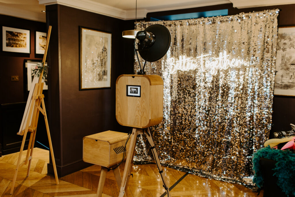 the slaughters manor house photo booth setup with retro wooden booth and silver backdrop, cotswolds
