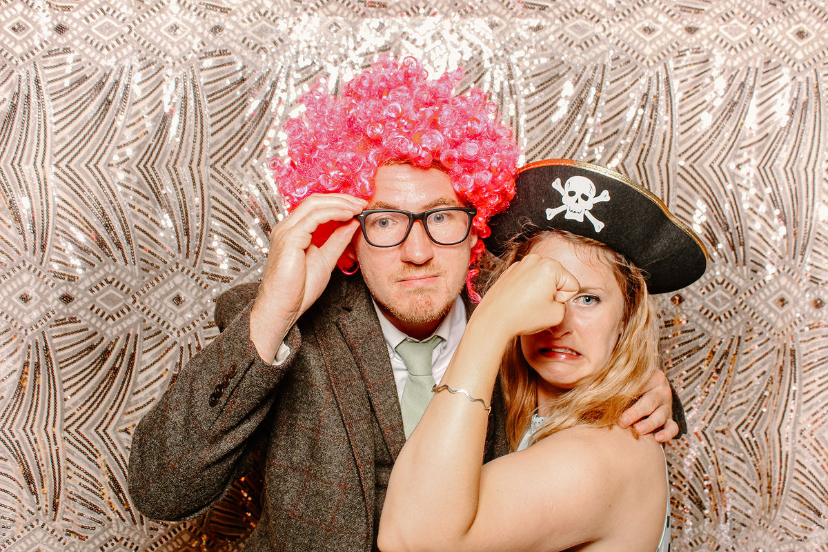 funny couple posing for mad hat photo booth at Coombe Lodge Blagdon wedding 