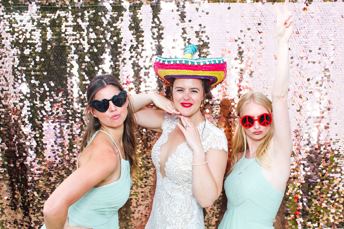 bride and friends posing during the wedding party for mad hat photo booth at lapstone barn