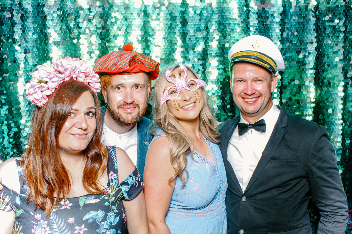Barn wedding venue photo booth with green sequins backdrop