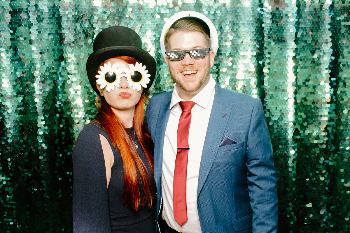 Barn wedding venue photo booth with green sequins backdrop