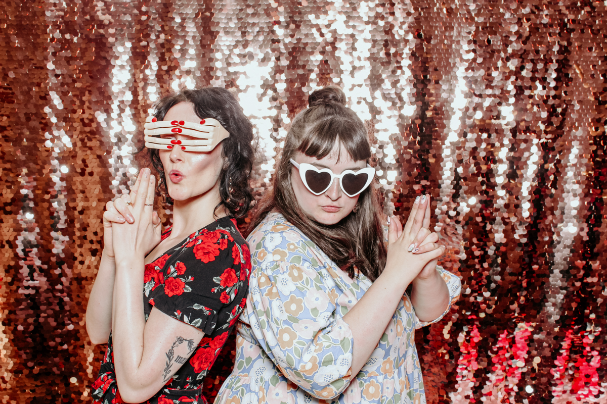 wedding guests posing for mad hat photo booth during a kingscote barn wedding