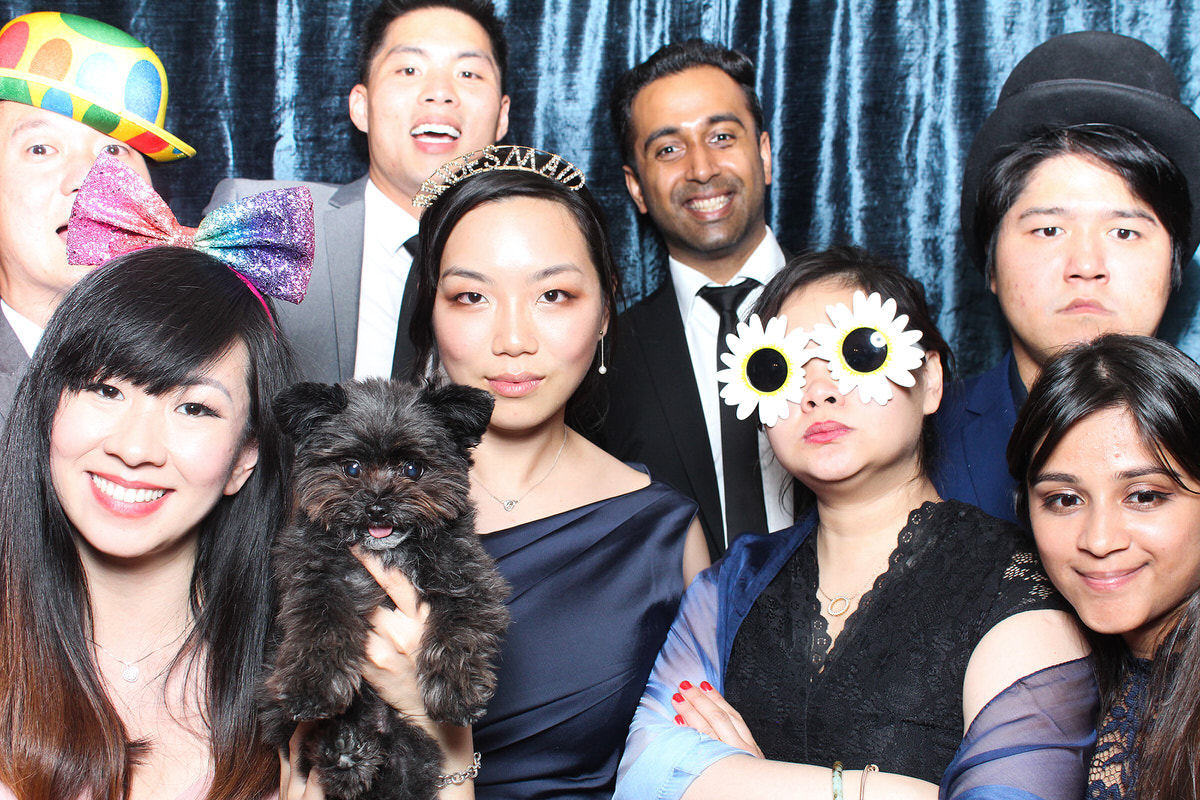 wedding guests posing in front of blue velvet backdrop for a whatley manor wedding photo booth event