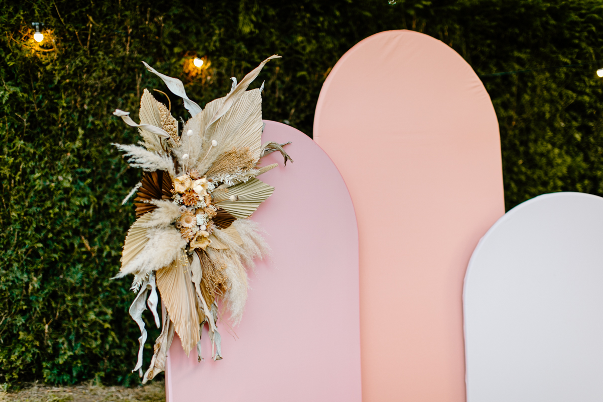 coral and blush arches for ceremony backdrop with dried flower arrangements