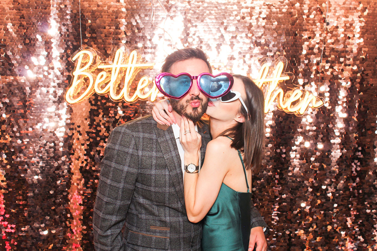 couple kissing during the photo booth entertainment for a cotswolds wedding at hyde house