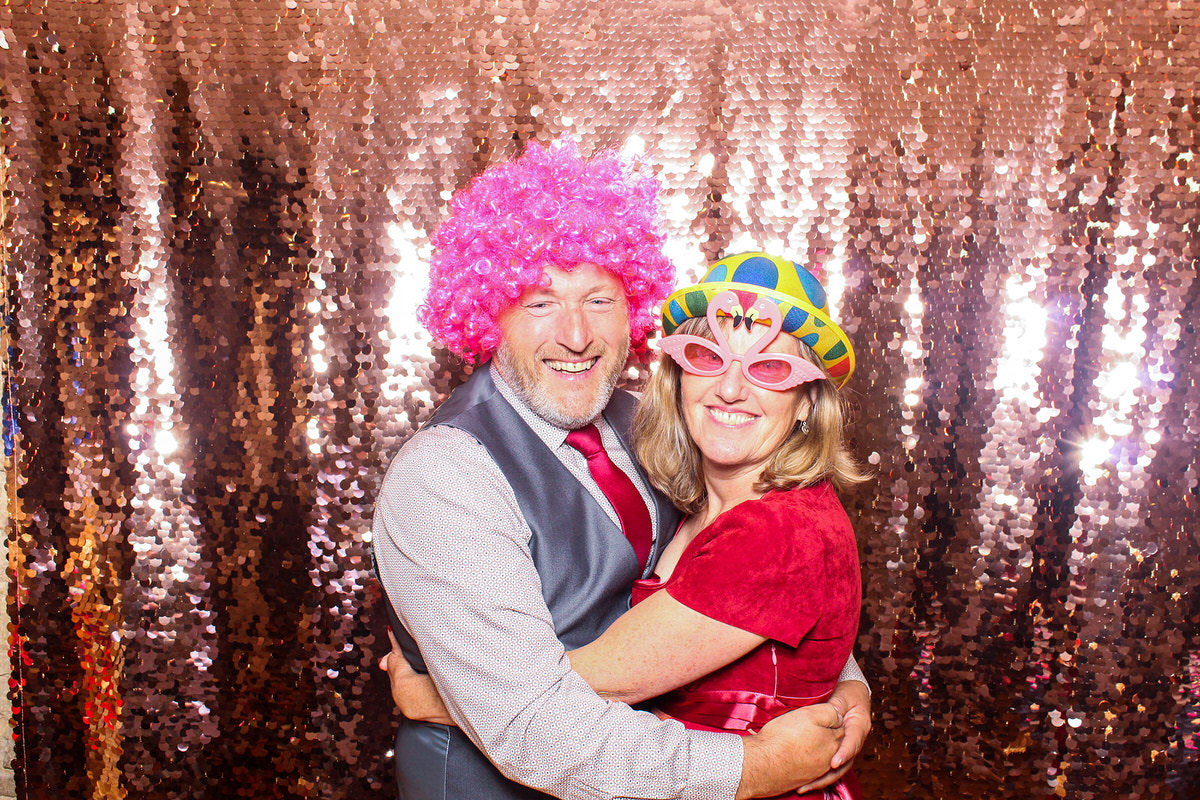 couple using the pink wig and props during a photo booth event at The Great Tythe Barn Wedding