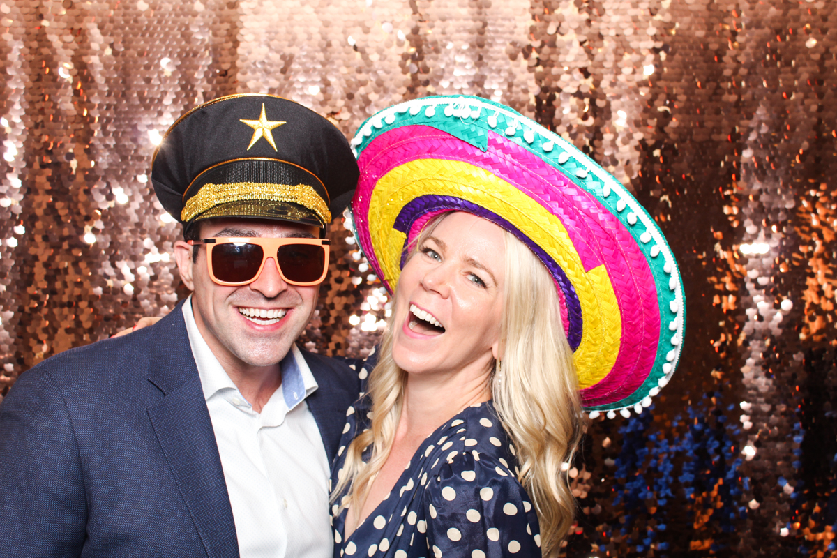 couple posing for photo booth with sequins backdrop, during a lapstone barn wedding