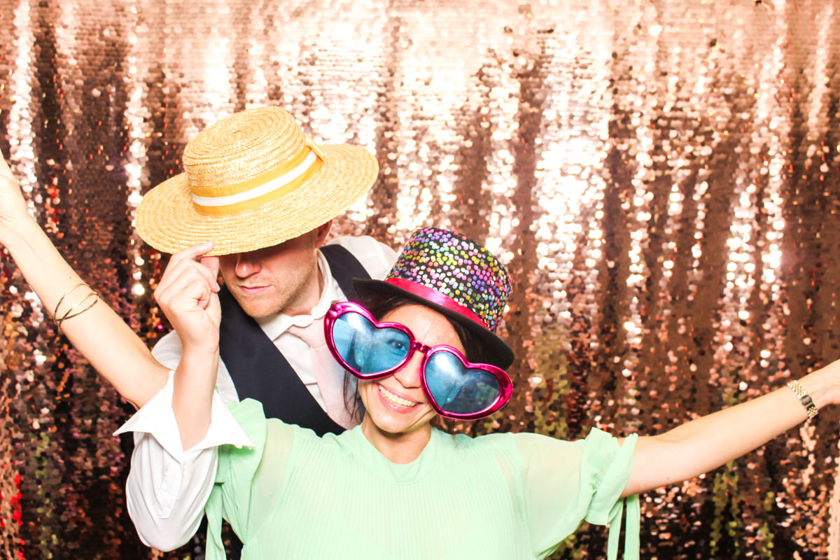 couple posing for mad hat photo booth during a lapstone barn wedding
