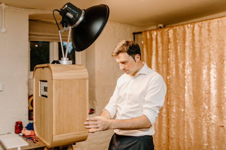 mad hat photo booth founder with wooden photo booth cotswolds
