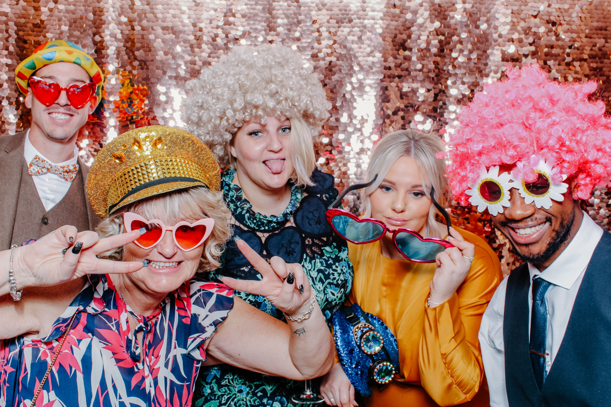 guests wearing wigs and hats during a wedding photo booth hire at yard space