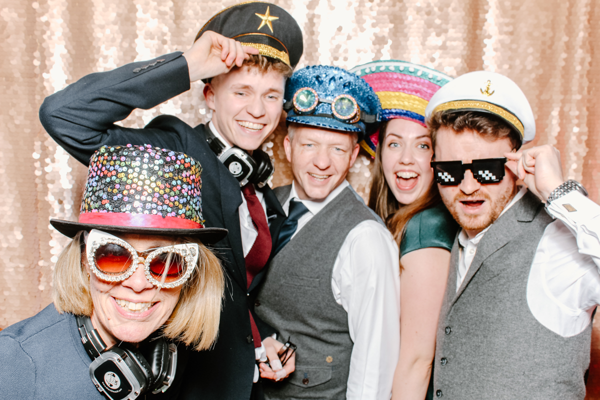 Gloucestershire photo booth hire for a wedding party entertainment with guests wearing props and posing against a blush sequins backdrop