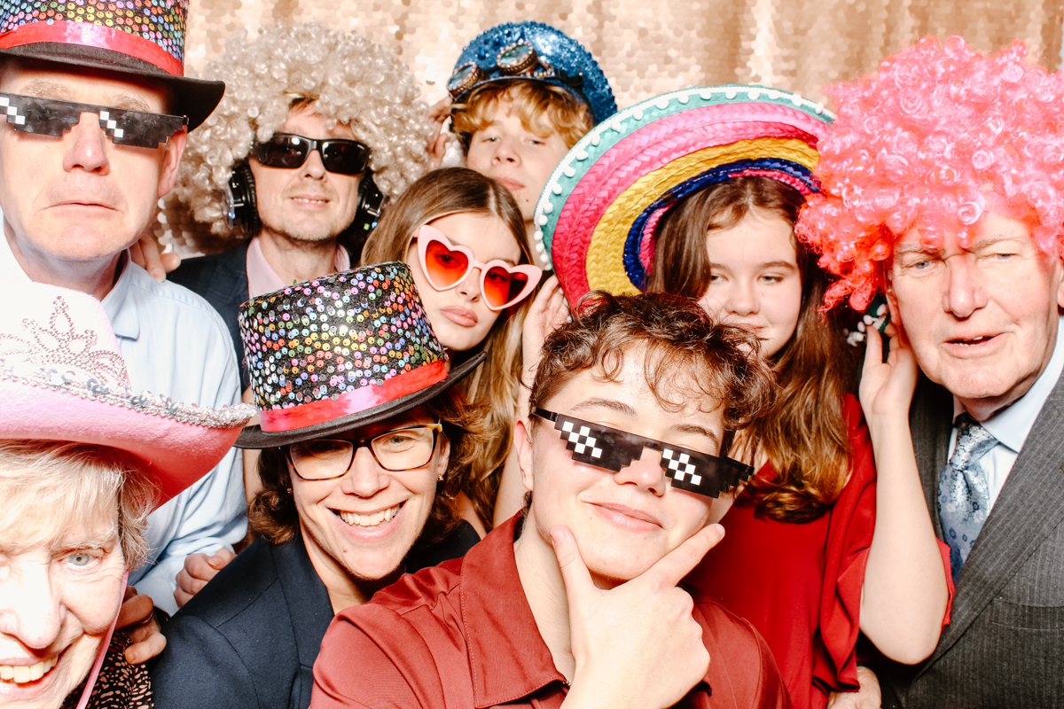 large group of guests posing against a sequins backdrop for a event party entertainment