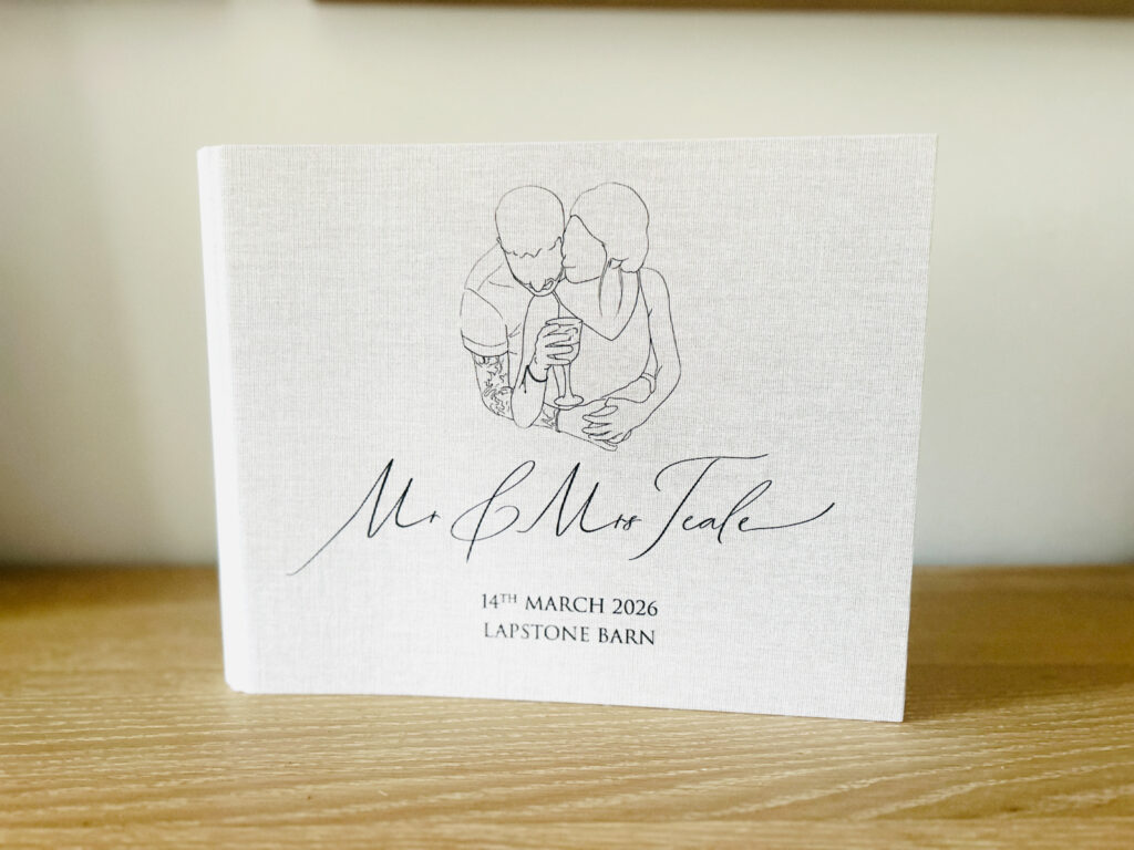 Custom linen cover guest book with couple logo and names on the front cover for a photo booth hire during a wedding party