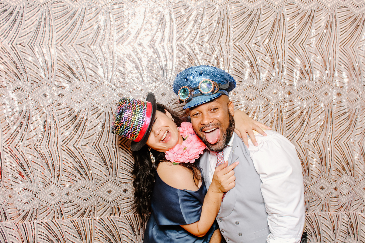 couple posing with boho sequins backdrop during a wedding reception