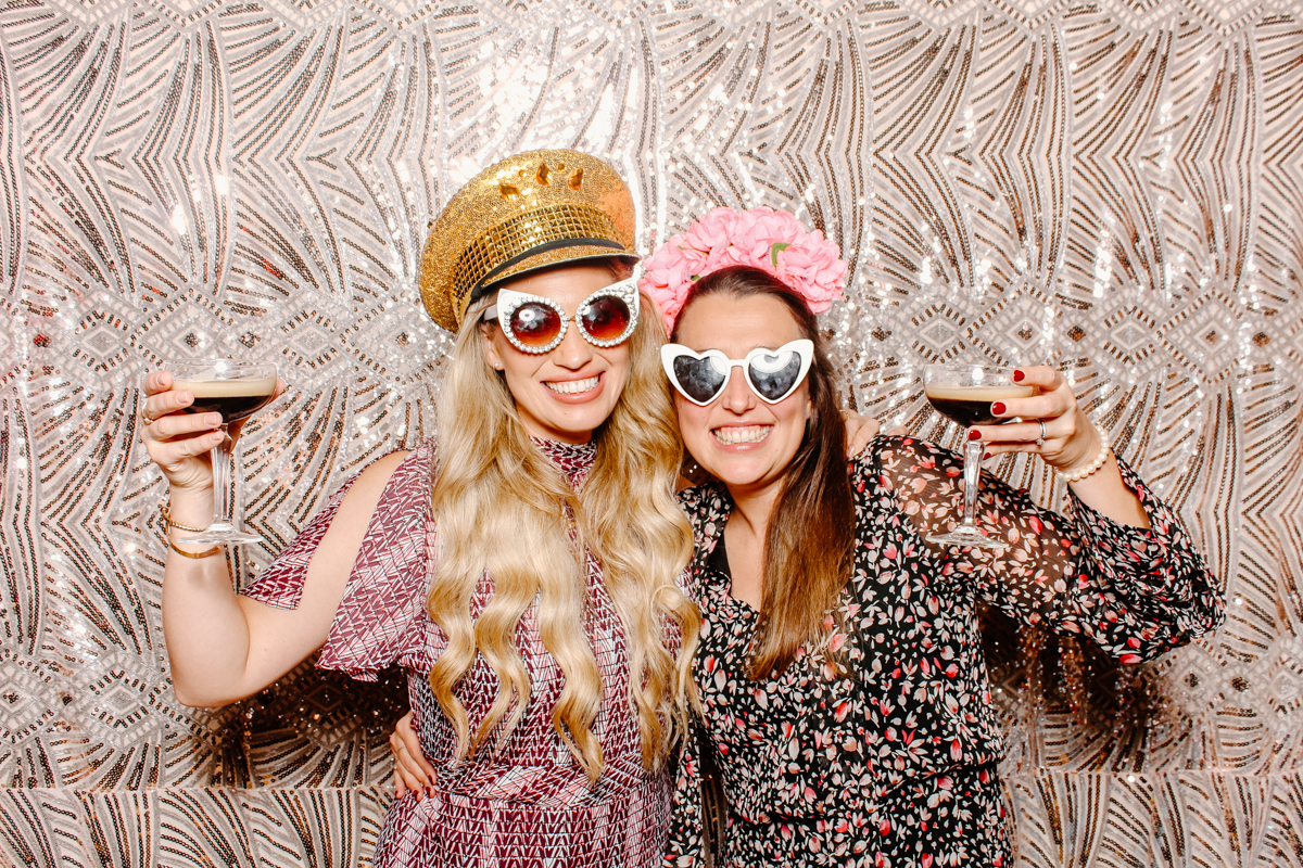 ladies holding martinis during a photo booth event in the evening at elmore court