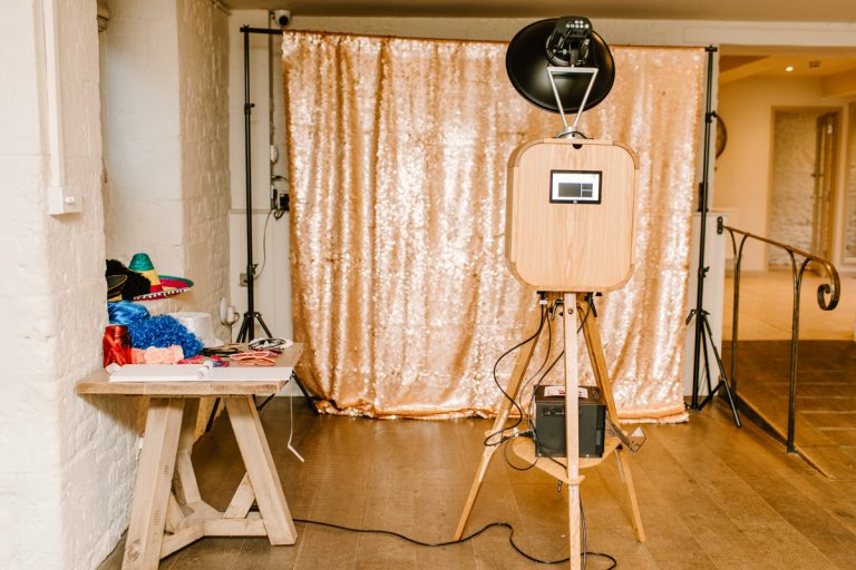 wooden photo booth with sequins backdrop behind