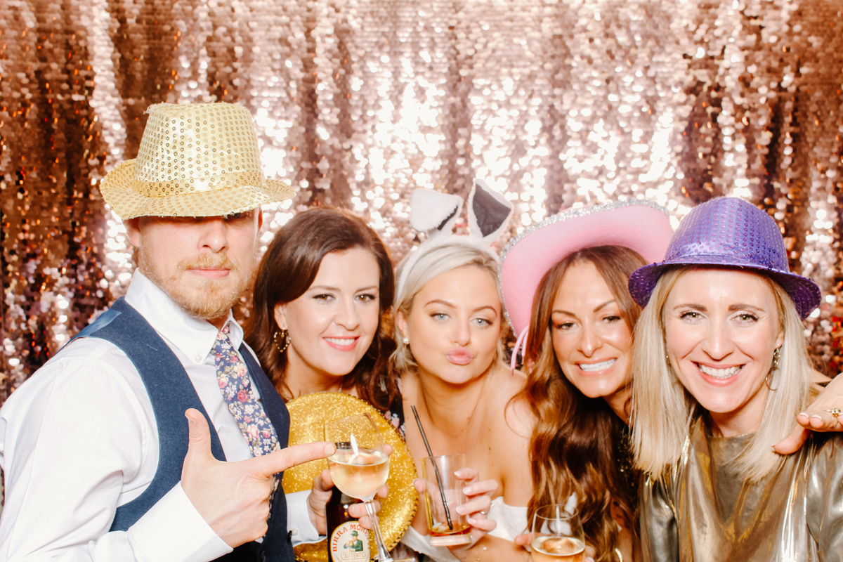 guests posing during a wedding party entertainment against a sequins backdrop