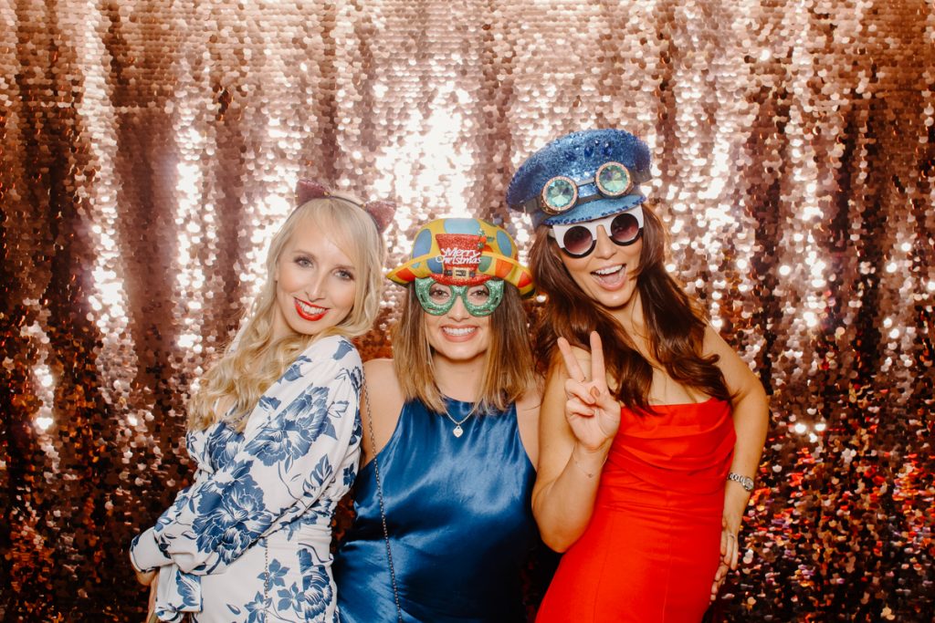 3 ladies wearing fun props, posing for a wooden Photo Booth Hire near Solihull venue 