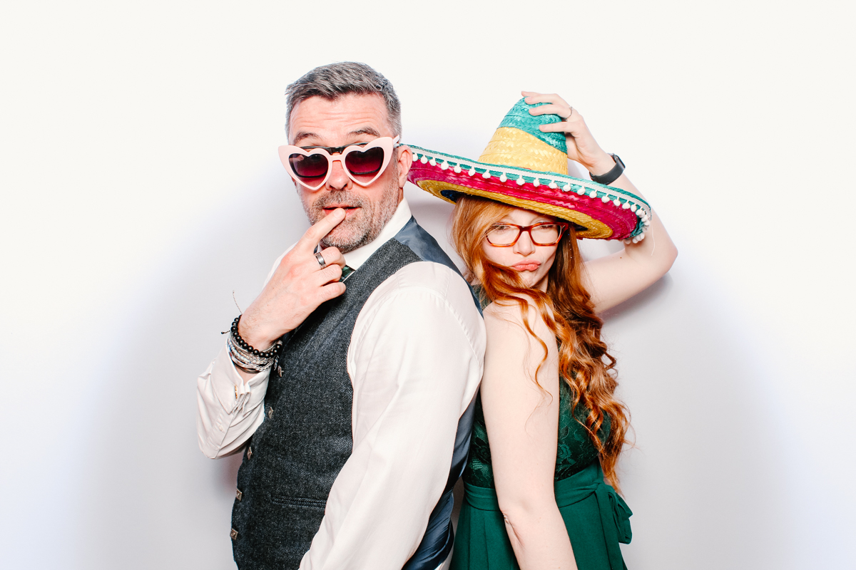 fun guests posing for a photo booth event with white backdrop for the swan hotel wedding 