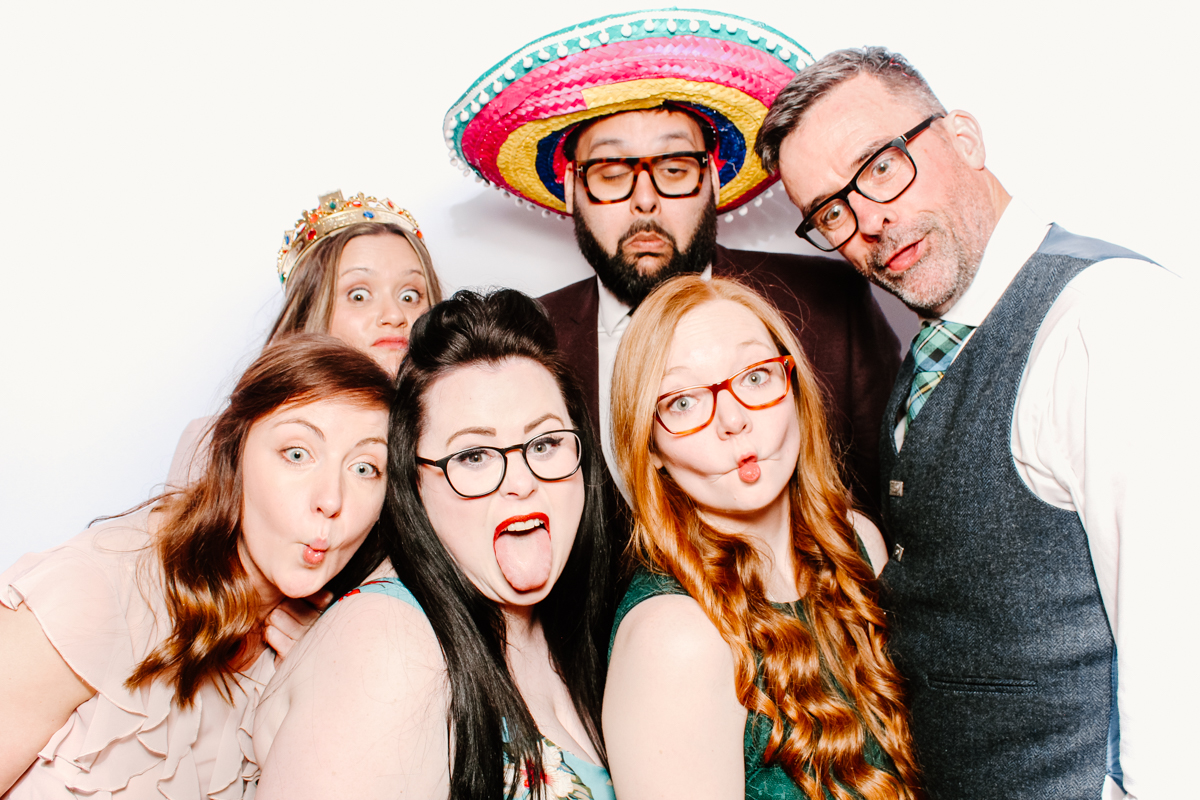 fun photo booth hire for a cotswolds wedding with a white backdrop and fun props