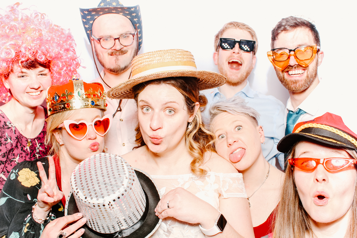 guests having fun with props at the swan hotel with a white backdrop 