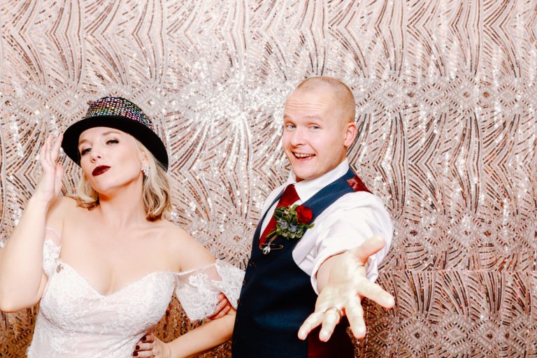 bride and groom posing for a photo booth hire during their wedding at Cotswold House Hotel