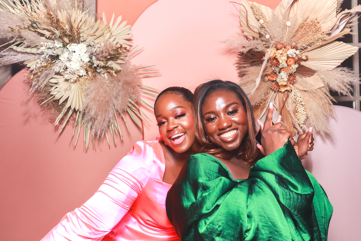 girls laughing while posing for cotswolds photo booth hire with arches backdrop