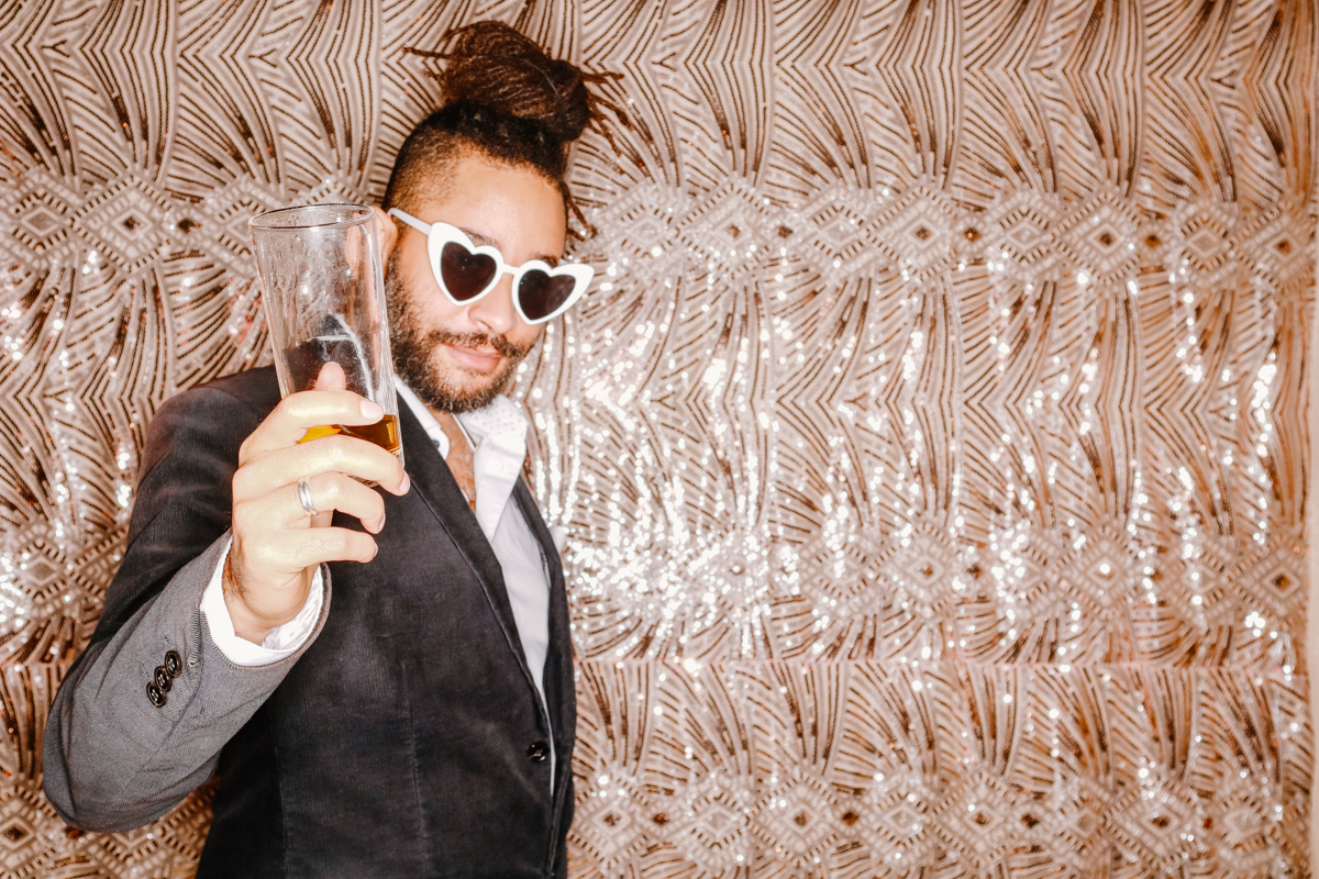 groom posing with heart-shaped glasses for a photo booth party