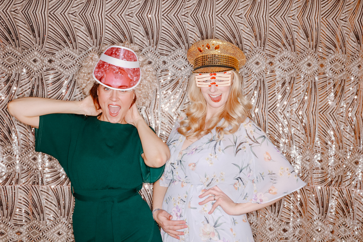 girls posing with a boho sequins backdrop during an old gore wedding party