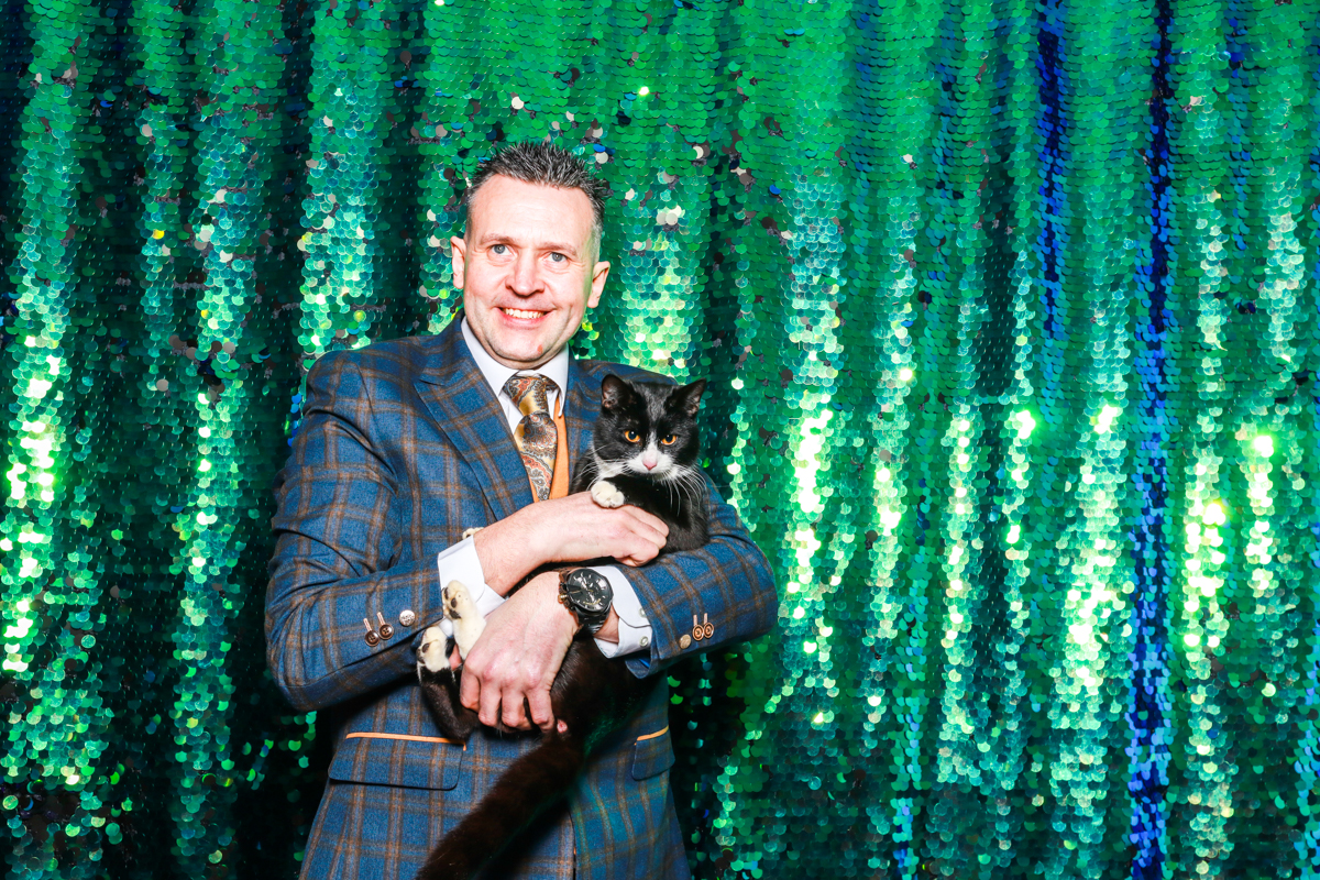 man with cat posing for the photo booth hire during the wedding reception at swallows nest barn