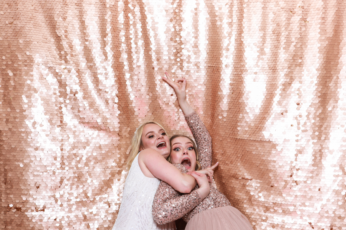 girls falling on blush sequins backdrop during a photo booth event ardington house