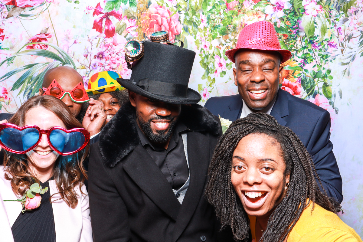 wedding guests during a wedding photo booth party entertainment with floral backdrop