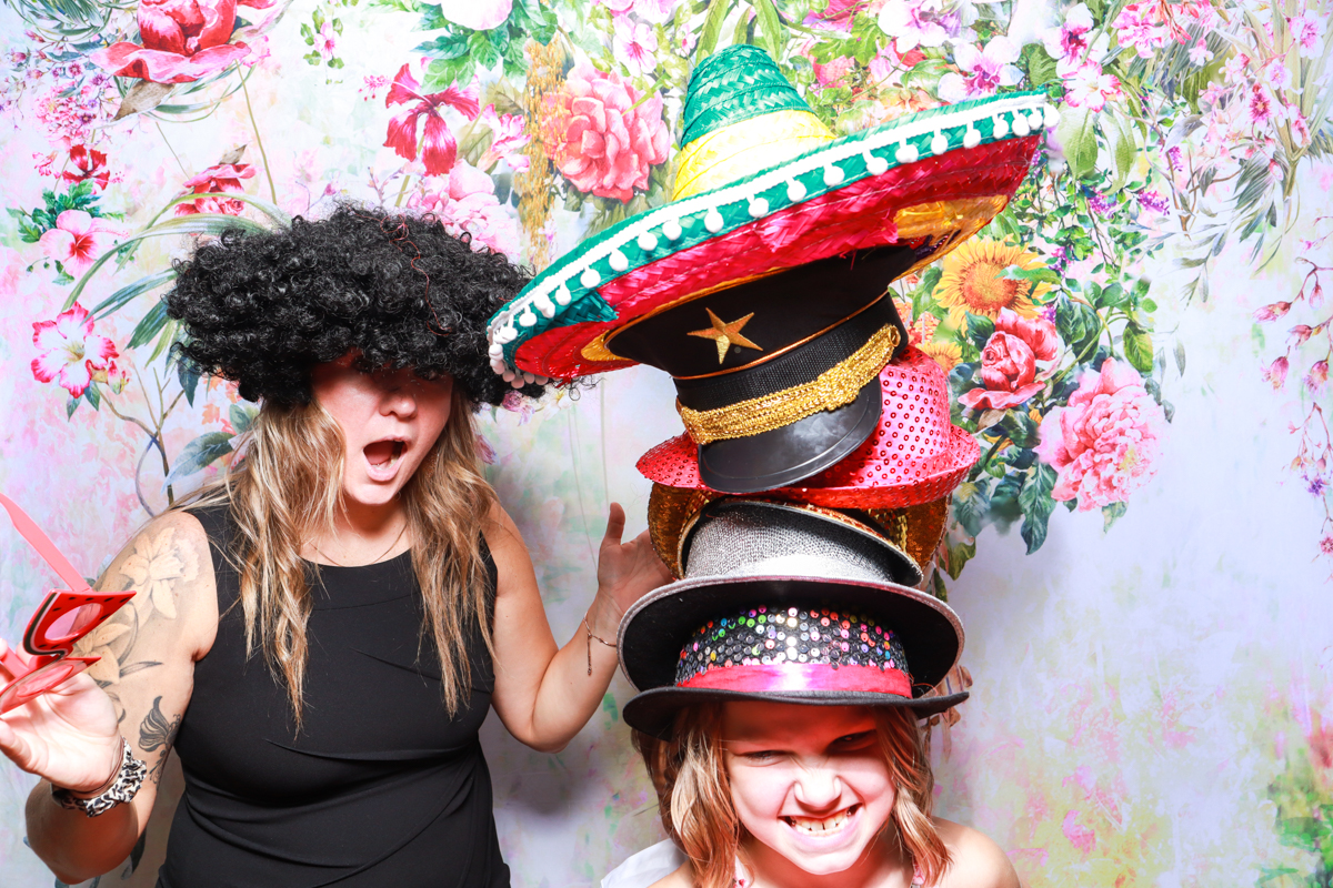 girl wearing many hats during a photo booth event in chipping norton cotswolds