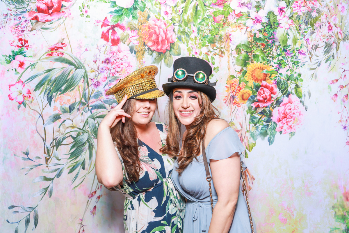 girls using a floral backdrop during a wedding photo booth hire cotswolds