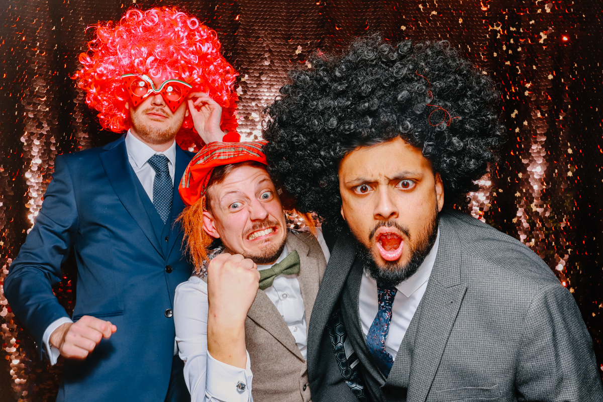 wedding guests posing for the cotswolds photo booth at stone barn wedding venue