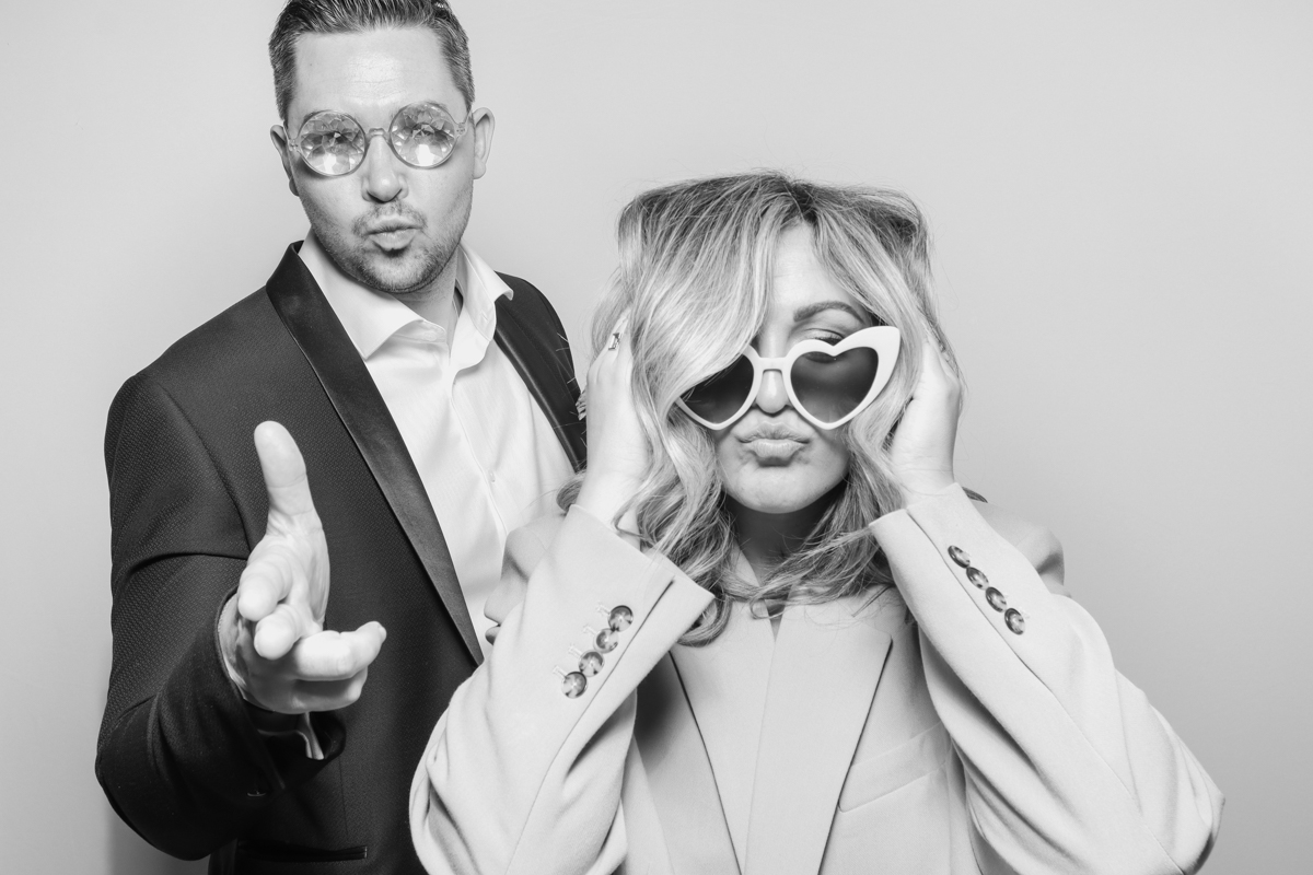 couples using the photo booth with a white backdrop for the kardashian style photo booth pictures