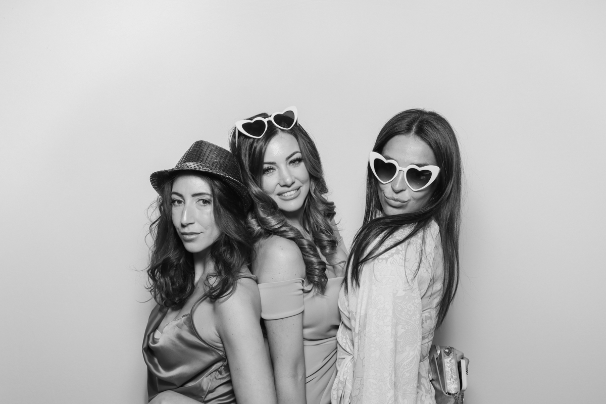 wedding guests using the photo booth with a white backdrop for the kardashian style photo booth pictures