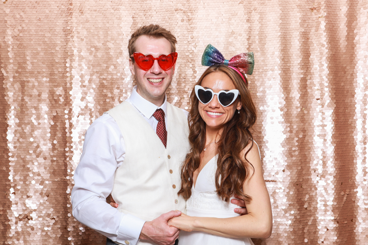 bride and groom wearing heart shaped glasses during a photo booth hire for their wedding reception