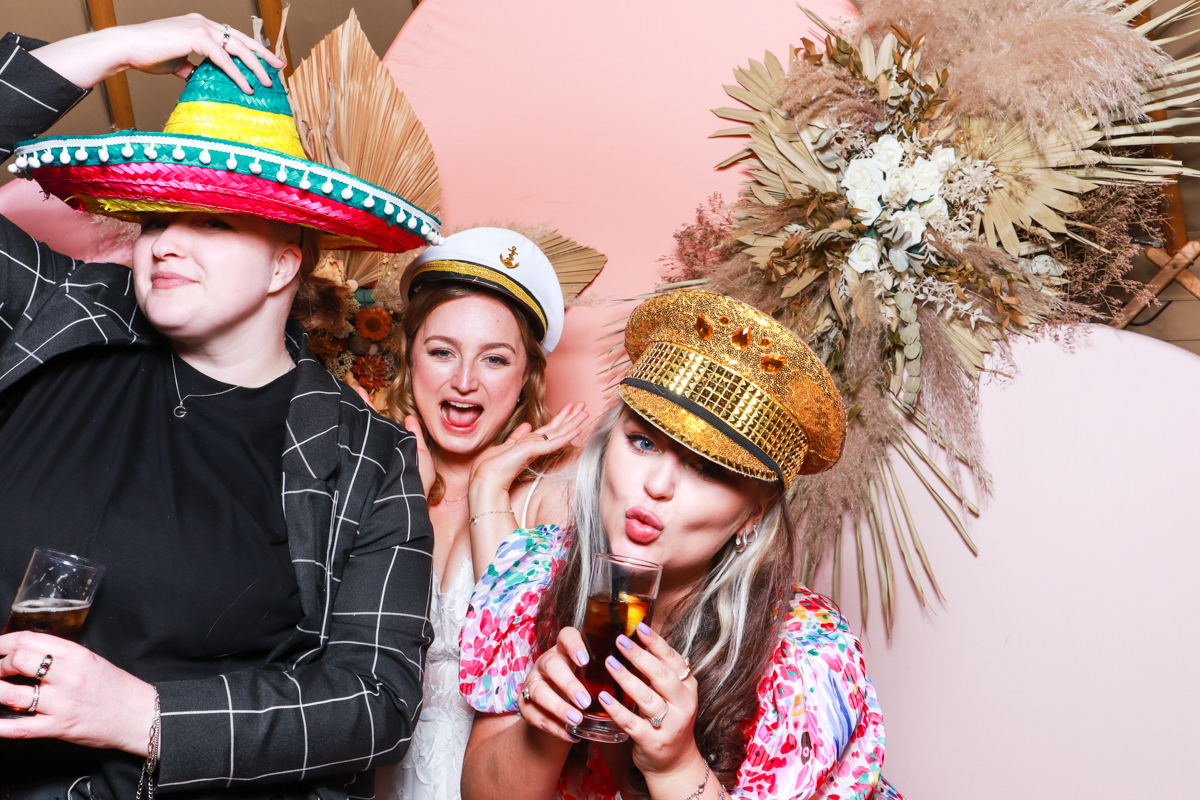 fun photo booth hire with pink backdrop and dried floral arrangements