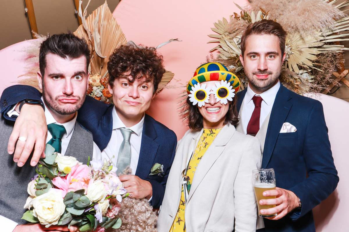 guests posing for a wooden photo booth hire at thorpe gardens wedding venue