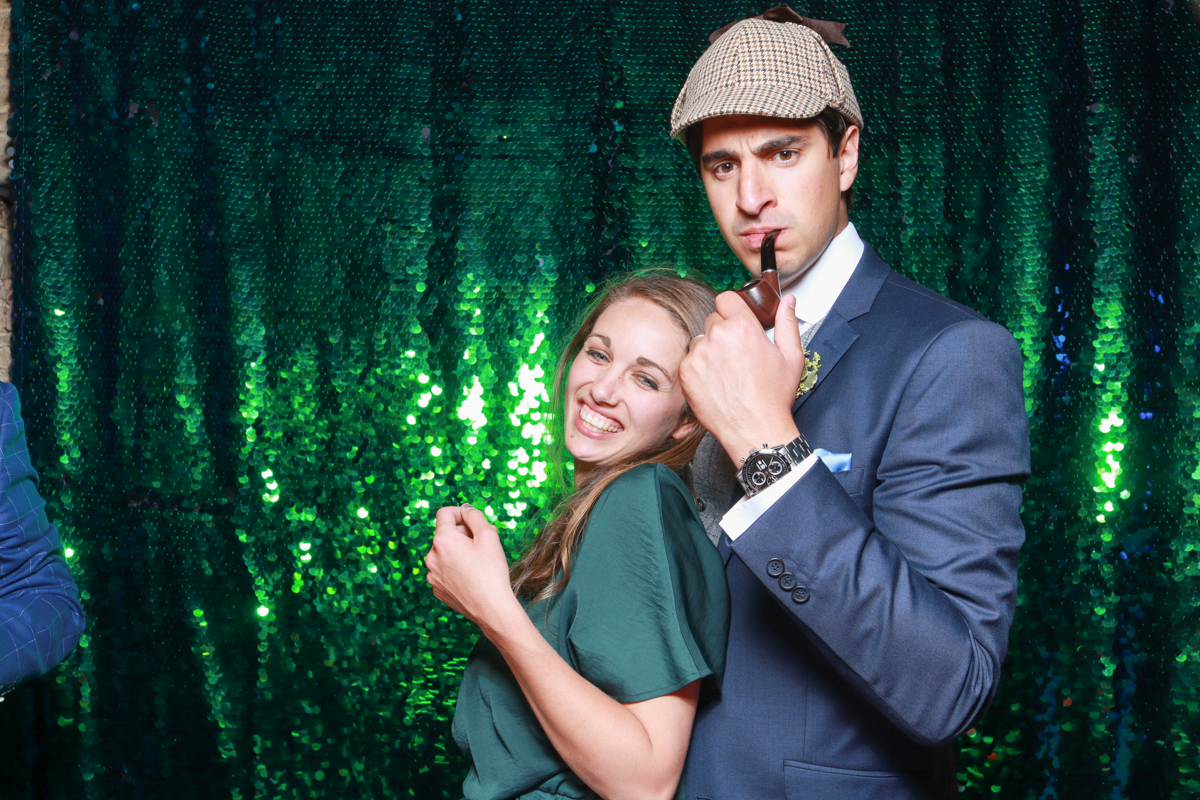 couple posing with props and green sequins for a cripps barn wedding in cotswolds