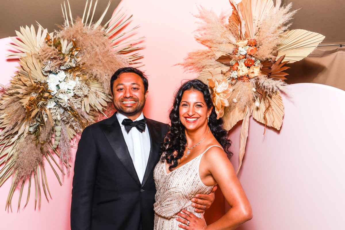couple posing with arches backdrop during a wedding party