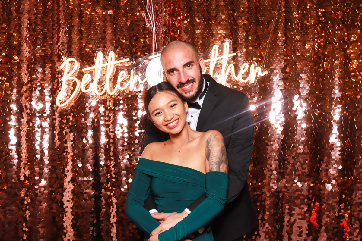 Better Together neon sign used as a photo booth backdrop on a champagne sequins backdrop